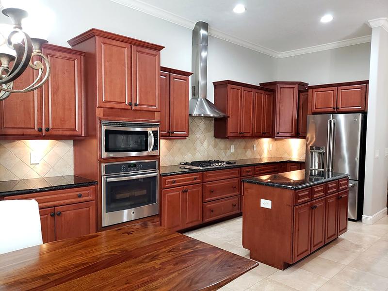 Before: dark cherry kitchen cabinets with black granite counters